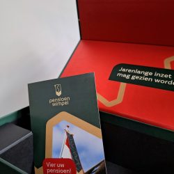 Brochure in de magneetdoos. Vier het pensioen met de pensioenwimpel. Het traditionele pensioencadeau.